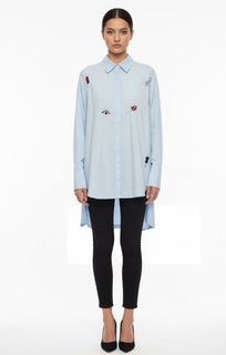 sky blue blouse with multiple brooches